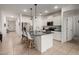 Modern kitchen with stainless steel appliances and a breakfast bar with white bar stools at 40380 W Jenna Ln, Maricopa, AZ 85138