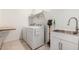 Laundry area with stainless steel sink, and modern white appliances at 40380 W Jenna Ln, Maricopa, AZ 85138