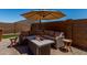 Outdoor patio with a fire pit, comfortable seating, and a shade umbrella at 40380 W Jenna Ln, Maricopa, AZ 85138