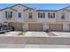Exterior view of townhomes featuring a private garage for each unit and well-kept landscaping at 4157 E Pinto Dr, Gilbert, AZ 85296