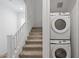 Convenient laundry area featuring a stacked washer and dryer unit next to staircase at 4157 E Pinto Dr, Gilbert, AZ 85296