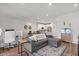 Open-concept living room with gray sofa, wood floors, and access to the kitchen at 4157 E Pinto Dr, Gilbert, AZ 85296