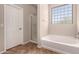 Well-lit bathroom with a soaking tub, a separate shower, and tile flooring at 43670 W Mcclelland Ct, Maricopa, AZ 85138