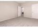 Cozy bedroom with neutral walls, carpet flooring, and an open doorway leading to the ensuite bathroom at 43670 W Mcclelland Ct, Maricopa, AZ 85138