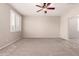 Cozy bedroom showcasing a ceiling fan, neutral walls, carpet, and a large window at 43670 W Mcclelland Ct, Maricopa, AZ 85138