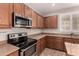 The kitchen features a stainless steel oven and microwave, ample counter space, and great natural light at 43670 W Mcclelland Ct, Maricopa, AZ 85138