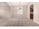 Open-concept living room with neutral walls, carpet, and tile flooring with arched entries at 43670 W Mcclelland Ct, Maricopa, AZ 85138