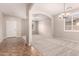 Spacious living room with neutral walls, carpet, and tile flooring with arched entries at 43670 W Mcclelland Ct, Maricopa, AZ 85138
