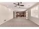 Open-concept living area flows into the kitchen, featuring tile flooring and abundant natural light at 43670 W Mcclelland Ct, Maricopa, AZ 85138