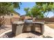 Outdoor kitchen with built-in grill and mini-fridge perfect for backyard entertaining at 43670 W Mcclelland Ct, Maricopa, AZ 85138