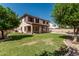 Expansive backyard with lush lawn, mature trees, covered patio, and private pool offers outdoor enjoyment at 4507 E Lantern Pl, Gilbert, AZ 85297