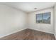 Inviting bedroom featuring neutral paint, wood floors, and a large window letting in natural light at 4507 E Lantern Pl, Gilbert, AZ 85297