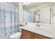 Bathroom featuring a toilet, wooden cabinets, and shower with patterned curtain at 5 N 87Th Ln, Tolleson, AZ 85353