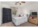 Bedroom features a comfortable bed, ceiling fan, and natural light, creating a welcoming space at 5 N 87Th Ln, Tolleson, AZ 85353