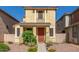 Inviting two-story home featuring a cozy porch, desert landscaping and a red entry door at 5 N 87Th Ln, Tolleson, AZ 85353