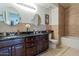 Spacious bathroom with granite countertop, double sink, oval mirrors, neutral tile, and combination tub and shower at 5335 E Shea Blvd # 2081, Scottsdale, AZ 85254