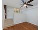 Well-lit bedroom featuring hardwood floors, a ceiling fan, and an adjacent stairwell at 581 S Roosevelt St, Tempe, AZ 85281