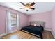 Inviting bedroom with plush bed, wood-look flooring, and window with sheer curtains for soft natural light at 5841 W Kesler St, Chandler, AZ 85226