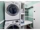 Laundry room with stacked washer and dryer, built-in shelves, and a small work area at 5841 W Kesler St, Chandler, AZ 85226