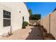 Charming brick patio with a cozy outdoor seating area featuring a unique water feature and mature landscaping at 5841 W Kesler St, Chandler, AZ 85226