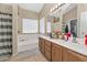 Well-lit bathroom includes double sinks, a soaking tub, and a window with blinds at 8599 W Athens St, Peoria, AZ 85382