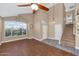 Bright living room with hardwood floors, a ceiling fan, and a view of the front yard at 8599 W Athens St, Peoria, AZ 85382