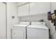Functional laundry room with washer, dryer, and overhead cabinets at 9389 N 87Th Way, Scottsdale, AZ 85258