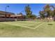 Turf tennis court is surrounded by a security fence and landscaping offering recreation at 9389 N 87Th Way, Scottsdale, AZ 85258