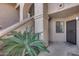 Inviting entrance with stucco walls, stairs, and mature landscaping with a wrought iron security door at 9450 N 94Th Pl # 116, Scottsdale, AZ 85258
