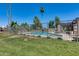 A fenced community pool area featuring lounge chairs and palm trees, perfect for relaxation at 9450 N 94Th Pl # 116, Scottsdale, AZ 85258