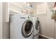Functional laundry room with modern washer and dryer, complemented by white shelves for storage at 963 S Colonial Dr, Gilbert, AZ 85296