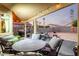 Covered backyard patio with dining and lounge seating, grill and a lush landscape at 12026 W Salter Dr, Sun City, AZ 85373