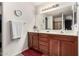 Bathroom with double vanity, large mirror and warm, wood cabinets at 12026 W Salter Dr, Sun City, AZ 85373