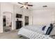Primary bedroom with a queen bed, ceiling fan, ensuite bath, and spacious walk in closet at 12026 W Salter Dr, Sun City, AZ 85373