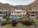 Aerial view of backyard and swimming pool surrounded by lush landscaping and mountain views at 13631 E Windrose Dr, Scottsdale, AZ 85259