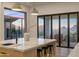 Bright kitchen featuring an island with seating and access to an outdoor balcony at 13631 E Windrose Dr, Scottsdale, AZ 85259