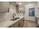 Well-lit laundry room with gray shaker cabinets, neutral subway tile backsplash, and durable quartz countertop at 13631 E Windrose Dr, Scottsdale, AZ 85259