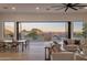 Open living room with a view to the outside through expansive glass doors; dining set to the left and sofa to the right at 13631 E Windrose Dr, Scottsdale, AZ 85259