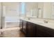 Elegant bathroom featuring a double vanity, soaking tub, and frosted glass shower door at 1390 E Jasper Dr, Gilbert, AZ 85296
