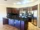 Stylish kitchen featuring stainless steel appliances, dark cabinets, and a large granite island at 1390 E Jasper Dr, Gilbert, AZ 85296