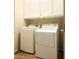 Bright laundry room with washer, dryer, and overhead storage cabinets at 1390 E Jasper Dr, Gilbert, AZ 85296
