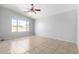 Spacious bedroom with tiled floors, a ceiling fan, and a large window, providing natural light at 1501 E Sunland Ave, Phoenix, AZ 85040