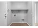 Practical laundry space offers connections, shelf, tile flooring, and easy access at 1501 E Sunland Ave, Phoenix, AZ 85040