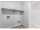 Functional laundry area includes tile flooring, utility connections, and shelf for storage at 1501 E Sunland Ave, Phoenix, AZ 85040