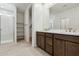 Modern bathroom featuring double sink vanity, walk-in shower, and shelving provides convenience at 15349 W Cottontail Ln, Surprise, AZ 85387