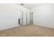 A bright bedroom with neutral carpet features two doors and white walls at 15349 W Cottontail Ln, Surprise, AZ 85387