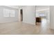 Open concept living room with tile floors, large windows, and view into the kitchen at 15349 W Cottontail Ln, Surprise, AZ 85387