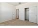A bedroom features neutral carpet, a walk-in closet, and an open doorway at 15357 W Cottontail Ln, Surprise, AZ 85387