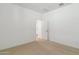 A bedroom features neutral carpet, bright white walls, and an open doorway at 15357 W Cottontail Ln, Surprise, AZ 85387