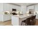 Modern kitchen featuring white cabinets, stainless steel appliances, and an island with seating at 15357 W Cottontail Ln, Surprise, AZ 85387